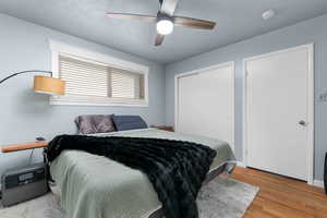 Bedroom with a closet, light wood-style floors, and ceiling fan