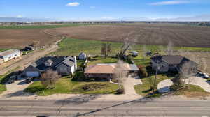 Aerial view of sparsely populated area featuring rows of crops and a mountainous background