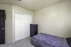 Bedroom with light carpet and a closet