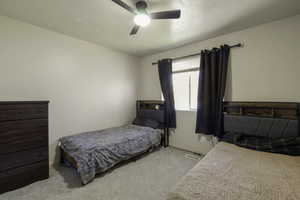 Bedroom with ceiling fan and light carpet