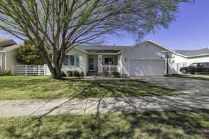 Single story home with a porch, a garage, and concrete driveway