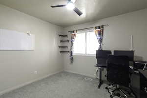 Office area featuring light colored carpet and ceiling fan