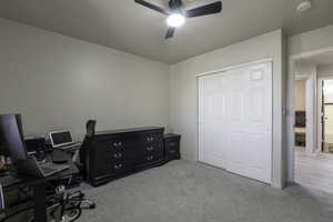 Office area with light carpet and a ceiling fan