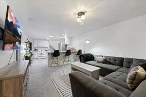 Living area featuring light carpet and recessed lighting