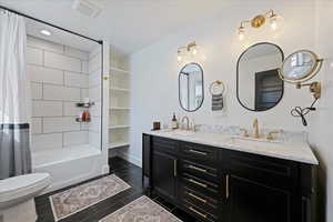 Bathroom with double vanity, shower / bath combo, and recessed lighting
