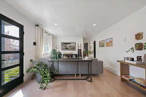 Living area with light wood-type flooring and recessed lighting