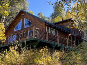 Back of house featuring log veneer siding and a wooden deck