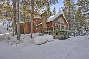 Snow covered house featuring a deck