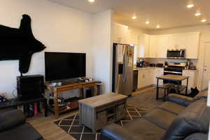 Living area with wood-style floors and recessed lighting