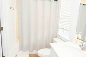 En suite bathroom with vanity and shower / tub combo with curtain