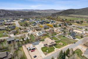 Aerial view of property and surrounding area with a mountainous background and nearby suburban area