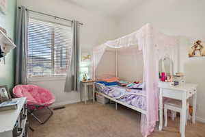 Bedroom featuring light carpet and baseboards