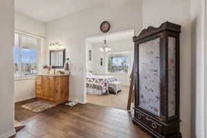 Bathroom featuring ensuite bathroom, vanity, dark wood-style floors, and suspended lighting