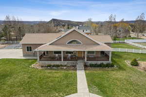 View of front facade with covered porch, roof with shingles, stucco siding, and a mountain view