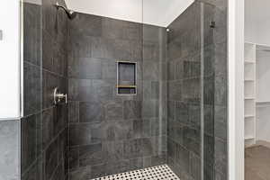 Bathroom featuring a stall shower and a spacious closet