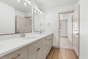 Full bathroom featuring double vanity and light wood-style flooring