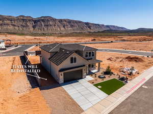 View of front of property featuring a mountain view, concrete driveway, a garage, stone siding, and stucco siding