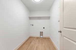 Laundry room featuring light wood-type flooring, hookup for a washing machine, and hookup for an electric dryer