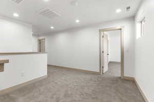 Unfurnished room with light colored carpet and recessed lighting