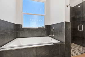 Full bath featuring a stall shower and a garden tub