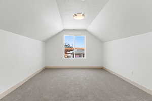 Bonus room with carpet flooring and baseboards