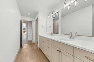 Bathroom featuring double vanity, light wood-style floors, and recessed lighting