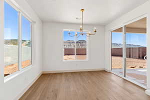 Unfurnished dining area featuring suspended lighting, light wood-style floors, and a mountain view