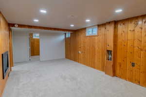 Below grade area featuring recessed lighting, wood walls, and carpet flooring