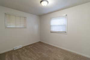 Empty room featuring carpet floors and baseboards