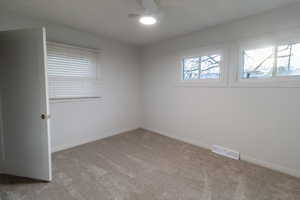 Spare room featuring carpet floors and ceiling fan