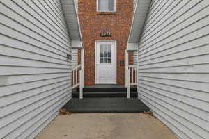 Property entrance featuring brick siding