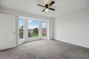 Unfurnished room with a ceiling fan and carpet floors