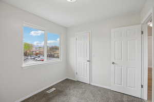 Unfurnished bedroom with light colored carpet and a closet
