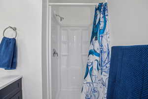 Bathroom featuring a shower stall and vanity