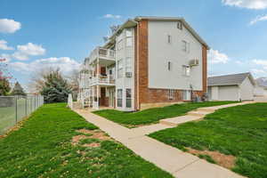 View of side of home featuring brick siding and a balcony