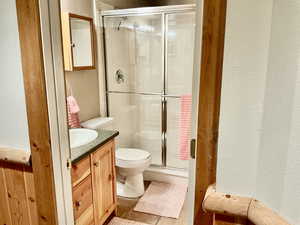 Bathroom with vanity, a stall shower, and a textured wall