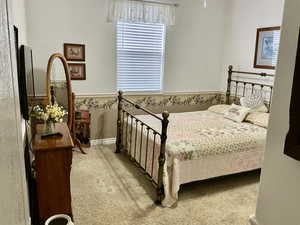 Bedroom featuring light colored carpet and baseboards