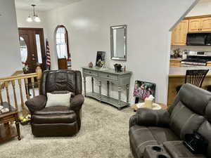 Living room featuring light colored carpet and a chandelier