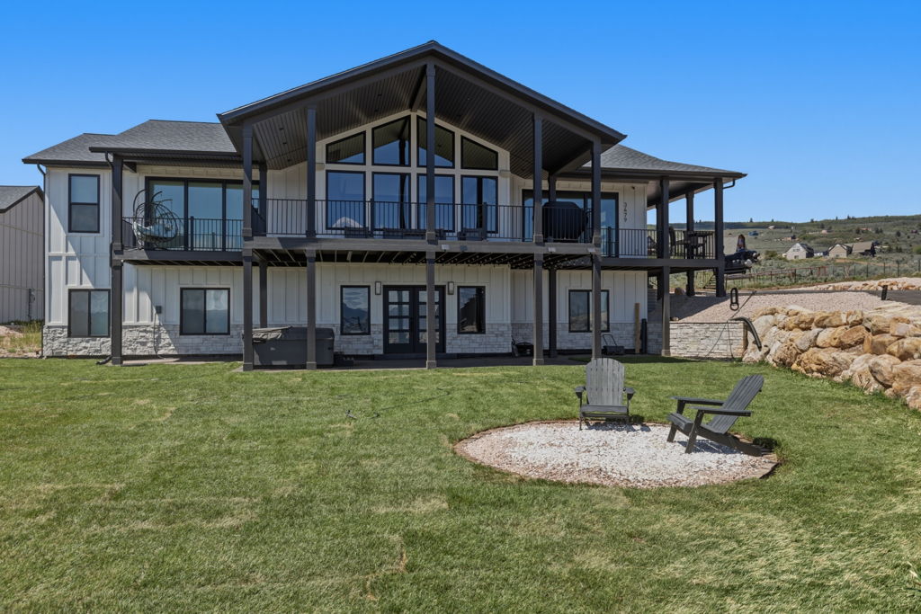 Contemporary exterior featuring white board and batten siding with stone accents