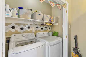 Laundry area featuring separate washer and dryer on main level but also hookups downstairs