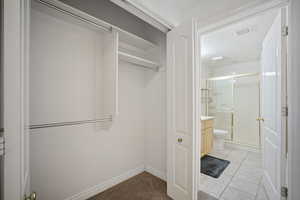 Walk in closet with light tile patterned flooring and light colored carpet