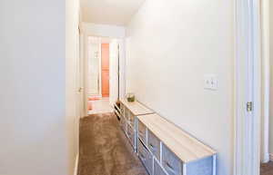 Corridor with dark carpet and a textured ceiling