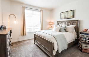 Bedroom with dark carpet and baseboards