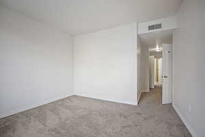 Empty room featuring light carpet and baseboards