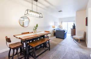Dining room featuring light colored carpet and baseboards
