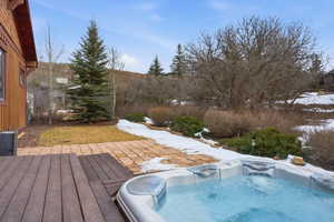 Snow covered pool with a wooden deck