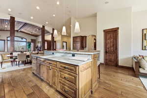 Kitchen with open floor plan, a kitchen breakfast bar, light wood-style flooring, hanging light fixtures, and a spacious island