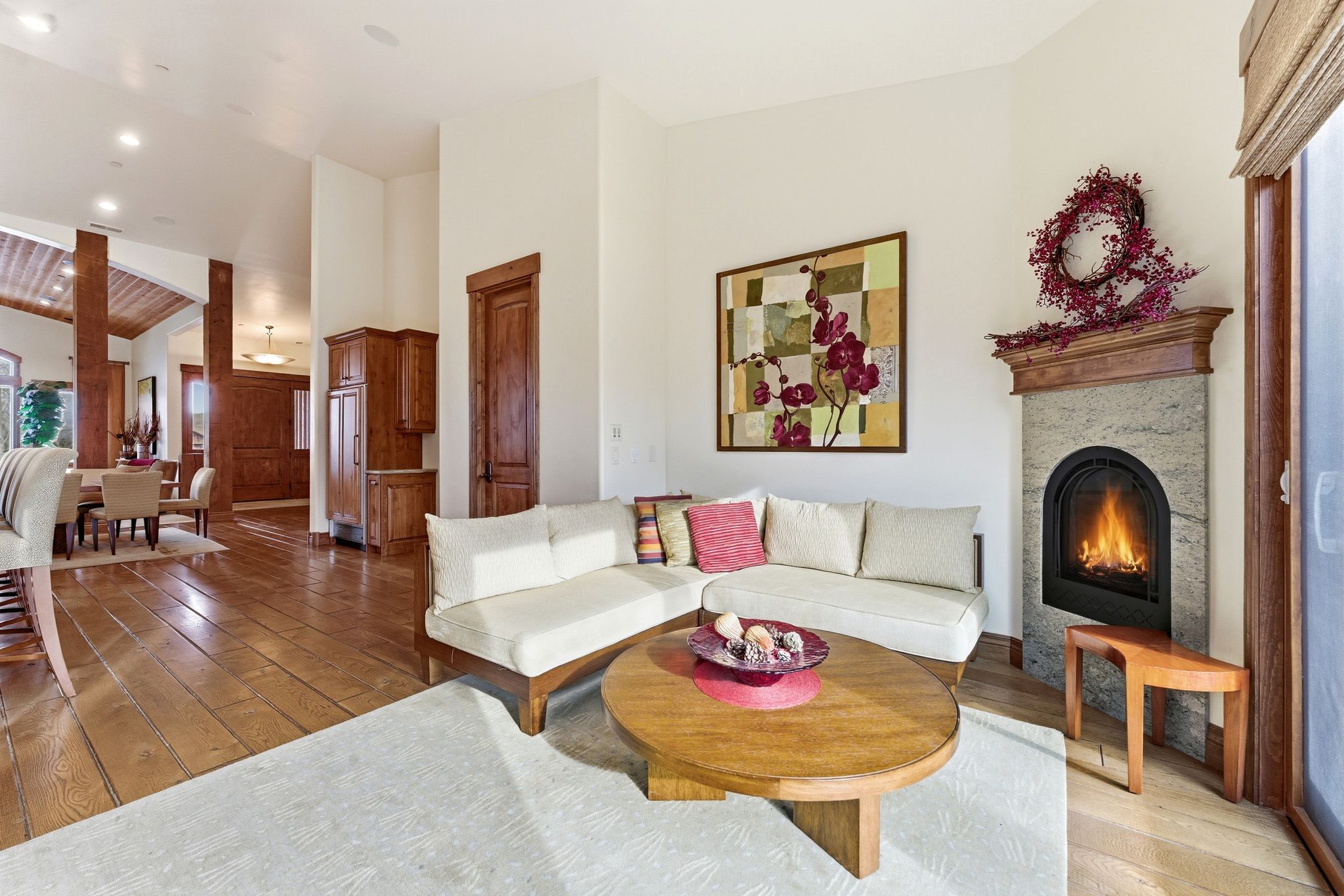 Living room featuring wood-type flooring, a fireplace, vaulted ceiling, and recessed lighting