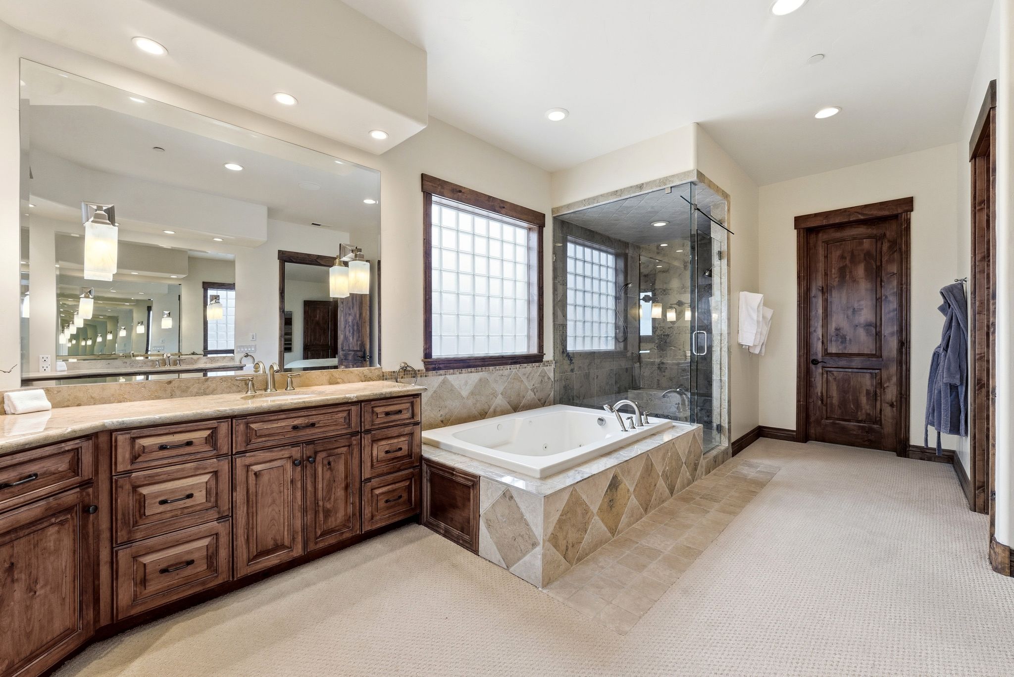 Full bath featuring light colored carpet, vanity, a stall shower, a jetted tub, and recessed lighting