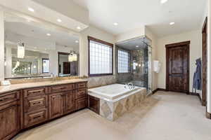 Full bath featuring light colored carpet, vanity, a stall shower, a jetted tub, and recessed lighting